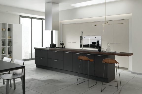 Modern kitchen with dark cabinets, wooden countertop, and stylish bar stools.