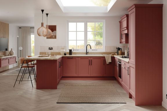 Modern kitchen with pink cabinetry, a skylight, and stylish pendant lighting.